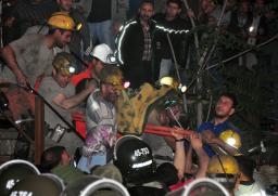 １３日、トルコ西部ソマの炭鉱で、救助された同僚を搬送する作業員ら（ＡＰ＝共同）